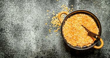 Seeds of lentils in a bowl . On rustic background. photo