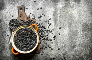 black beans in a bowl . On rustic background. photo