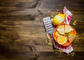 Fresh lemons in the bowl with the zest and grater on fabric. photo