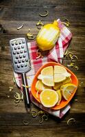 Fresh lemons in the bowl with the zest and grater on fabric. photo