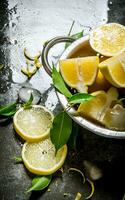 Fresh lemons in a saucepan with leaves and zest. photo