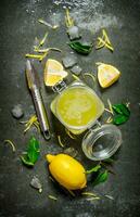 Lemon juice in the jar with the zest,leaves and ice around. photo