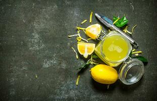 Lemon juice in the jar with the zest,leaves and ice around. photo