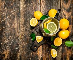 Fresh lemonade in a jug with slices of lemon . photo