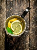 Fresh lemonade in a jug with slices of lemon . photo