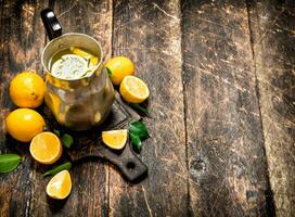 Fresh lemonade in a jug with slices of lemon . photo