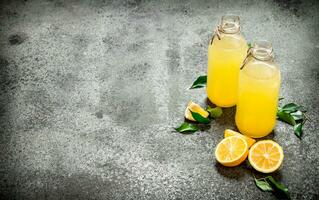 Lemonade in bottles with green leaves. photo