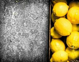 Fresh lemons in a wooden box. photo