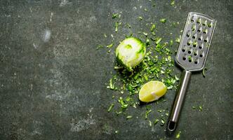 Lime zest and grater . Lime background. On stone table. photo