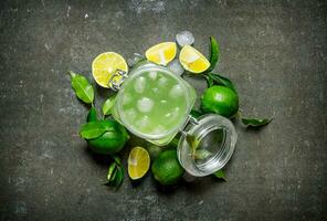 Lime background. The juice from the limes with ice and sliced limes around . photo