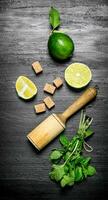 Lime style. Fresh mint, limes, black sugar and pestle. photo