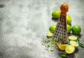 Grater with fresh limes . photo