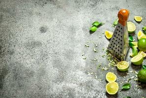 Grater with fresh limes . photo