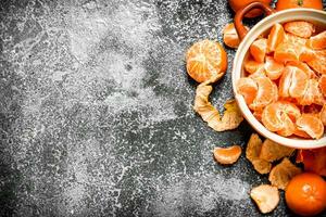 Peeled tangerines in a bowl. photo