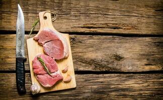 Fresh raw meat on a Board with a knife. photo