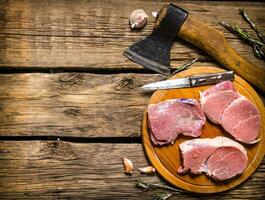 Fresh raw meat with spices and chopping axe. photo