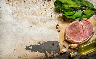 Raw fresh meat with garlic and oil on a wooden Board. photo