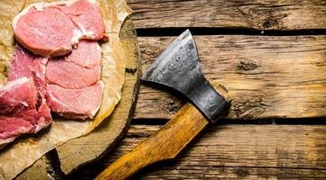 Fresh raw minced meat with an axe. photo