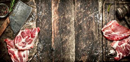 Raw meat background. Pieces of raw steak with spices and herbs. On wooden background. photo