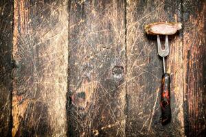 Meat grill. A piece of pork grilled on a fork . On the old wooden table. photo