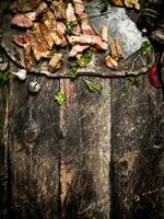 Meat grill. Sliced grilled pork with an old hatchet ,spices and herbs . photo