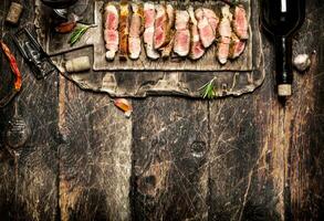 carne parrilla. piezas de Cerdo A la parrilla con especias y rojo vino. en el antiguo de madera mesa. foto