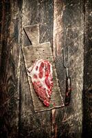Raw meat background. A piece of raw steak on cutting Board . On wooden background. photo