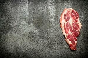 Raw meat background. A piece of Raw pork chops. On rustic background. photo