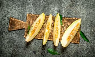 Slices of fresh melon on the old Board. photo