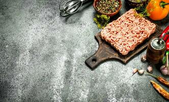 Meat stuffing with spices and herbs on a wooden board. photo