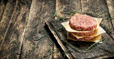 Raw burger from beef. On wooden background. photo