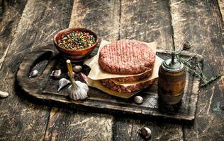 Raw burger with spices and herbs. photo