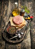 Raw burger from beef with spices and olive oil. photo