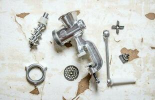 Disassembled manual grinder. On rustic background. photo