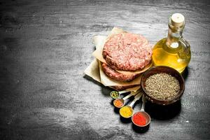 Raw burger with spices and herbs. photo