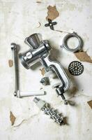 Disassembled manual grinder. On rustic background. photo