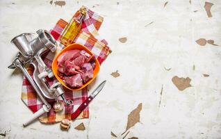Processing of meat. Raw fresh meat with a meat grinder . photo