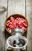 Preparated of meat. Cooking minced meat grinder. On a wooden table. photo