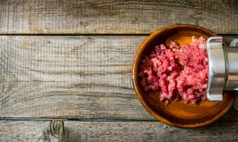 preparado de carne. Cocinando picado carne amoladora. en un de madera mesa. foto