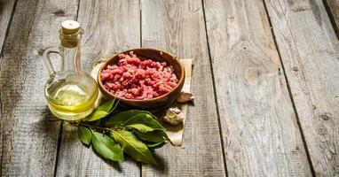 Fresh minced in a wooden Cup with onion and Bay leaf. photo