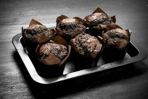 Chocolate muffins on a baking sheet. photo