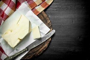 Butter with a knife on the board. photo