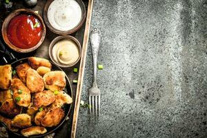 Chicken nuggets with different sauces on an old tray. photo