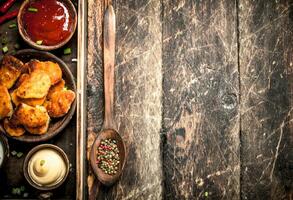 Chicken nuggets with various sauces. photo