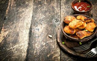 Chicken nuggets in a bowl with forks. photo