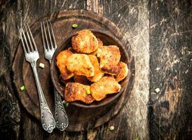 Chicken nuggets in a bowl with forks. photo