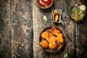 Chicken nuggets in a bowl with tomato sauce. photo