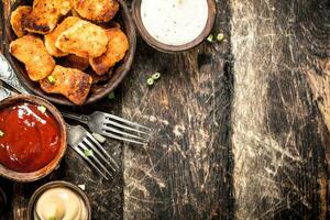 Chicken nuggets with various sauces. photo