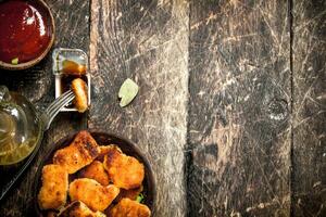 Chicken nuggets in a bowl with tomato sauce. photo