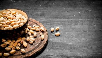 Pistachios in a bowl on the old Board. photo